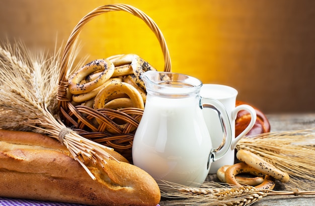 Brot und Bagels mit einem Krug Milch