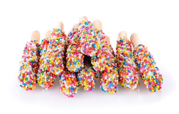 Foto brot- und regenbogenzuckerkugeln auf weißer wand