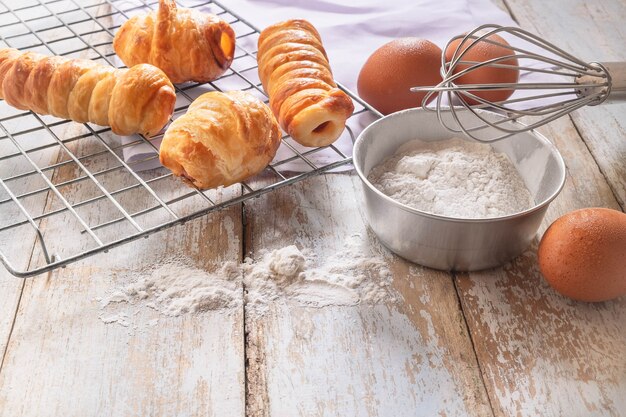 Brot und Schüssel Mehl auf hölzernem Hintergrund