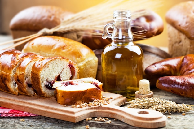 Brot und Weizen auf einem hölzernen Hintergrund