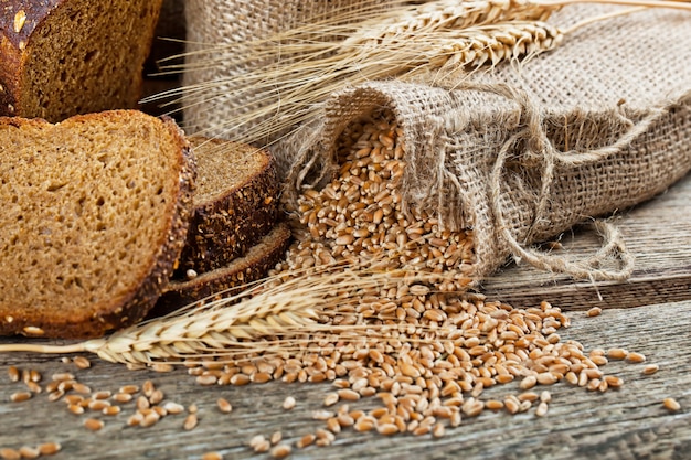 Brot und Weizen auf einem hölzernen Hintergrund