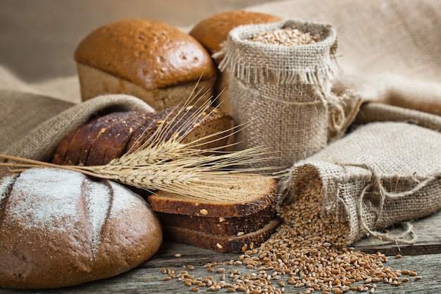 Brot und Weizen auf einem hölzernen Hintergrund