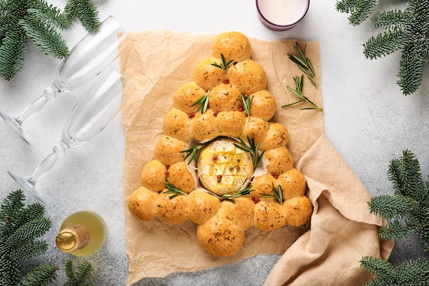 Brotbrötchen Weihnachtsbaum mit geröstetem Camembertkäse und Rosmarin auf rustikalem Hintergrund. Rezepte für den Urlaub. Weihnachtsmenü. Weihnachts- oder Weihnachtsgebäck. Ansicht von oben. Platz kopieren.