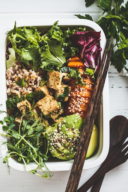 Brotdose mit gesundem veganen Essen. Bento Box mit Reis, Süßkartoffel, Tofu und Gemüse.