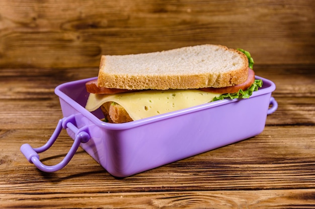 Brotdose mit Sandwiches auf einem Holztisch