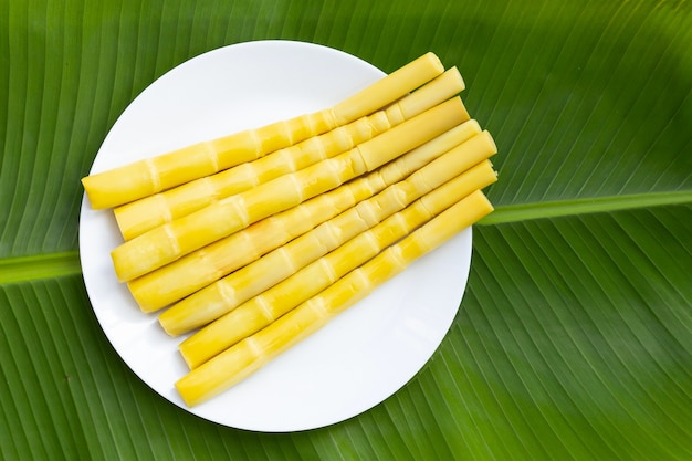 Brote de bambú conservado en placa blanca sobre hoja de plátano