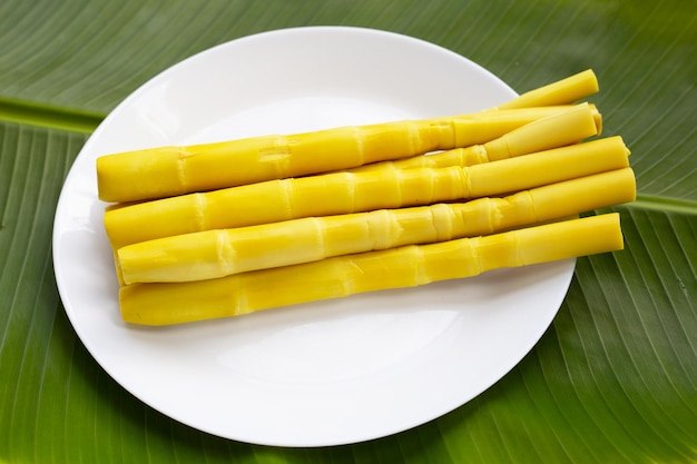 Brote de bambú preservado en plat blanco sobre hoja de plátano