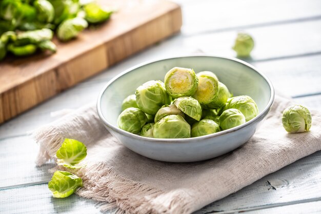 Brotes de brusseles frescos en un recipiente sobre la mesa de la cocina.