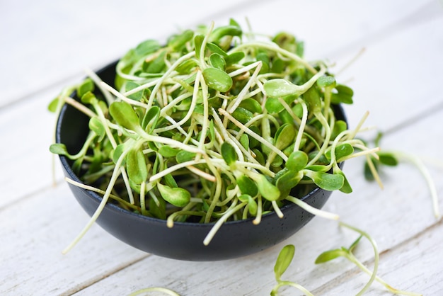 Brotes de girasol jóvenes verdes en un tazón para alimentos cocidos vegetales saludables