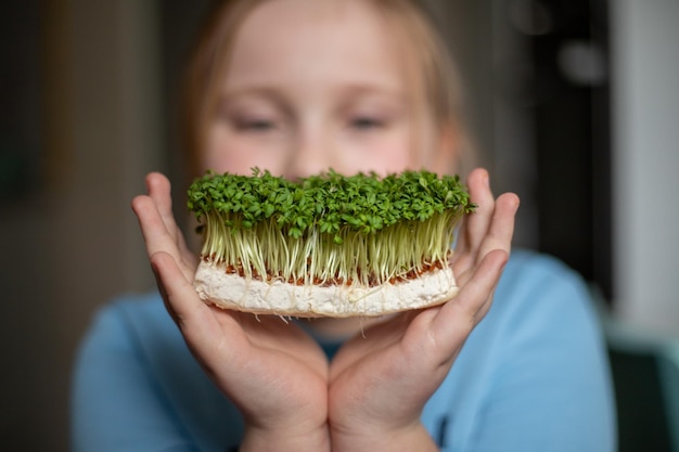 Brotes de microgreens en manos de niños Brotes crudos microgreens concepto de alimentación saludable