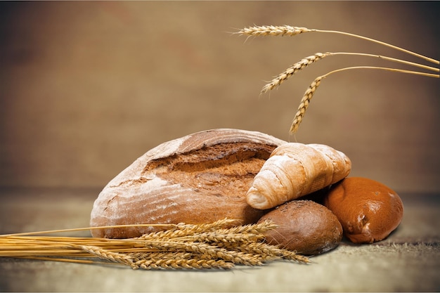 Brotlaibe mit Weizenähren auf verschwommenem Hintergrund