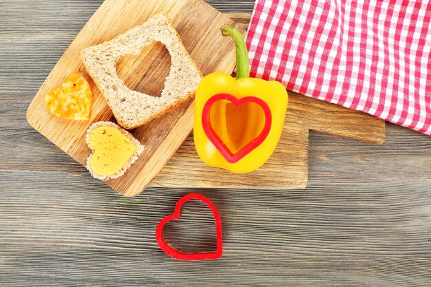 Brotscheibe mit Schnitt in Form von Herz und Pfeffer auf dem Tisch aus nächster Nähe