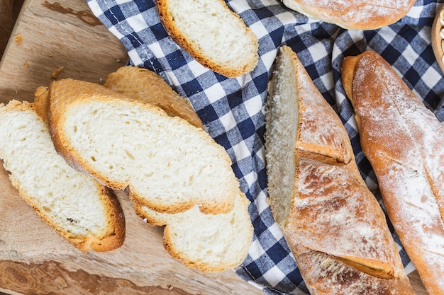 Brotscheiben in Scheiben geschnitten auf einem karierten Tuch Tischdecke