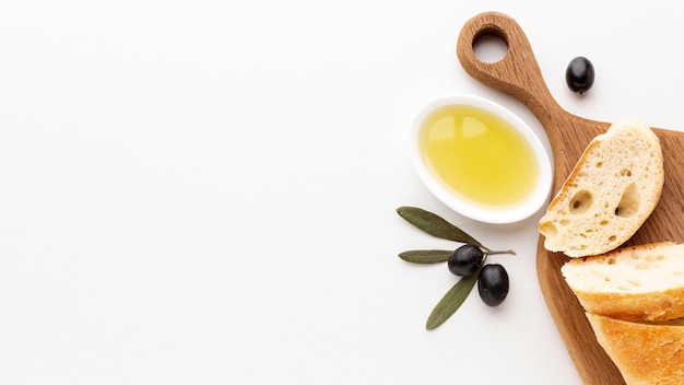 Brotscheiben mit Olivenöl und schwarzen Oliven mit Kopienraum