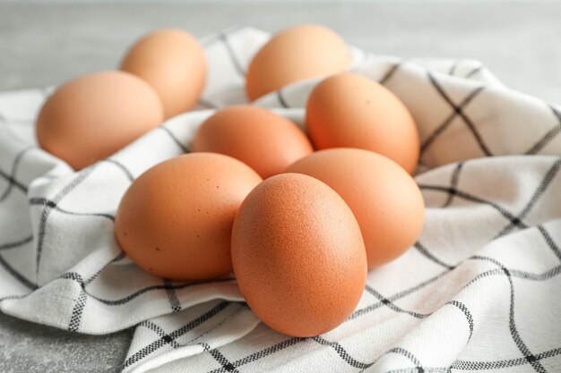 Brown huevos de gallina en una toalla de cocina en gris