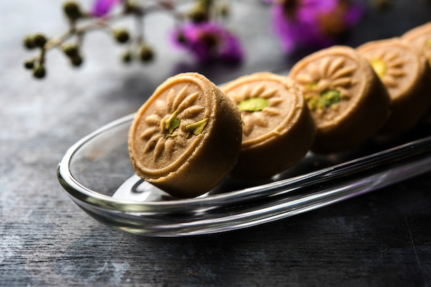 Brown Pera o pedha es un dulce indio elaborado con khoa, azúcar y aromas tradicionales, como semillas de cardamomo y pistachos. servido en un tazón o plato. enfoque selectivo