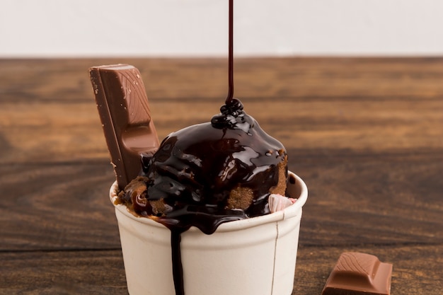 Brown-Sirup verzierte Eiscreme und geschnittene Schokolade