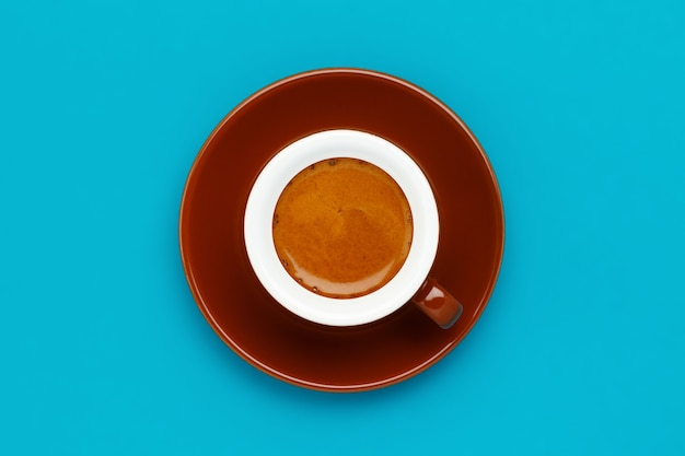 Brown xícara e Pires com café expresso em uma parede azul vista superior. Fechar-se