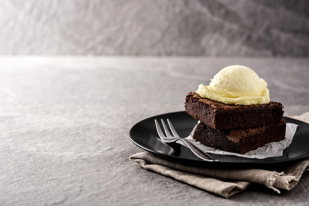 Brownie con bola de helado de vainilla sobre piedra gris