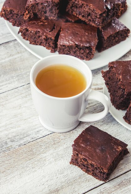 Brownie caseiro do biscoito com homem forte verde para o café da manhã. Foco seletivo. Fundo de madeira