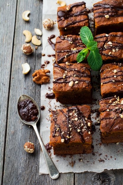 Brownie de chocolate con una calabaza sobre un fondo de madera vieja. Enfoque selectivo vista superior.