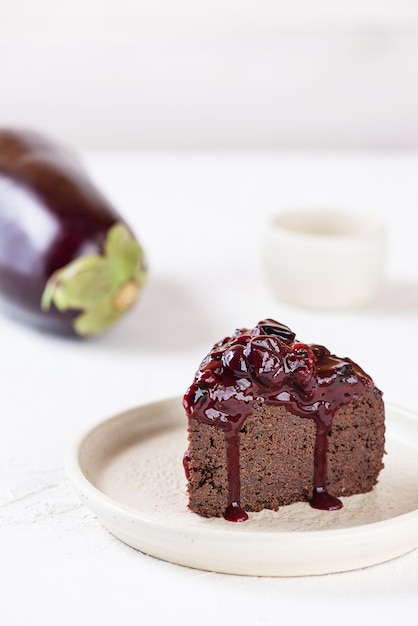 Brownie de chocolate con grosellas negras y berenjena sobre un fondo claro