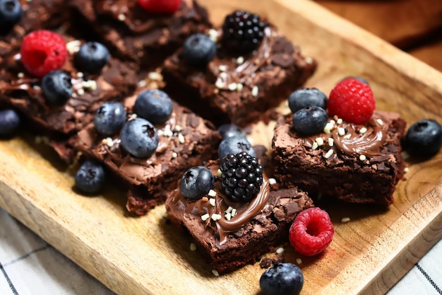 Brownie com frutas e chocolate em uma placa de madeira Brownies veganos caseiros