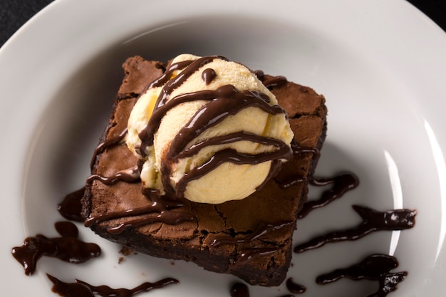 Foto brownie de chocolate com sorvete de baunilha no prato.