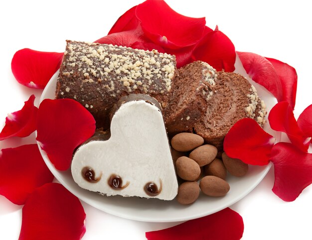 Brownie en forma de corazón con tarta en el plato con pétalos de rosa