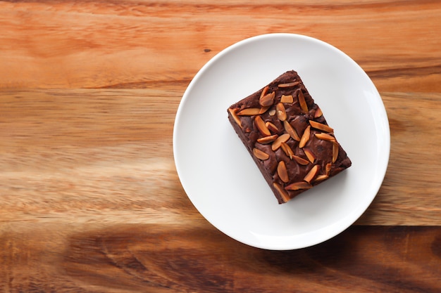 Brownie hecho en casa en la placa blanca. Postre dulce con cacao y café.