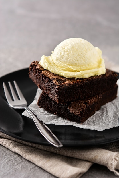 Brownie mit Vanilleeisschaufel auf grauem Stein