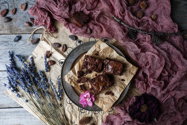 Brownies de chocolate caseros en placa de plata vintage decorada con lavanda y tela rosa sobre fondo de madera rústica Deliciosas galletas de postre para la vista superior de la fiesta del té enfoque selectivo