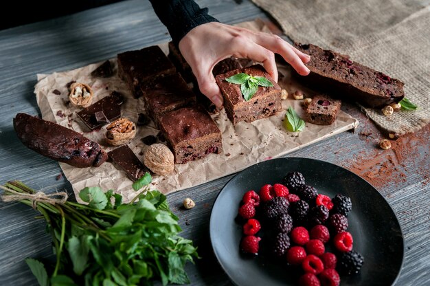 Foto brownies de chocolate caseros en superficie oscura.