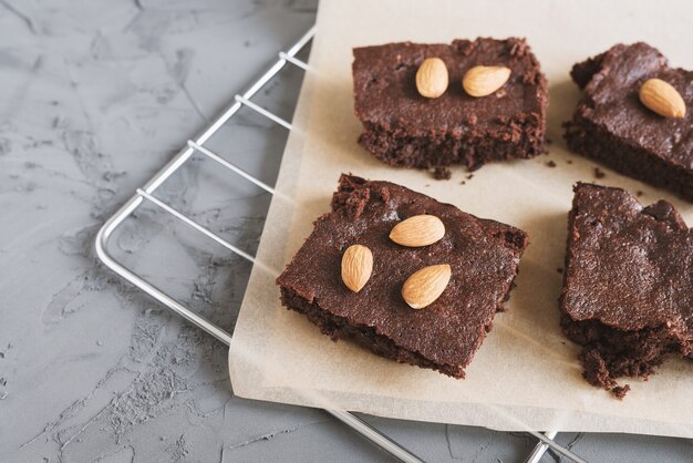 Foto brownies de chocolate caseiros com nozes de amêndoa servidos em uma bandeja com papel manteiga