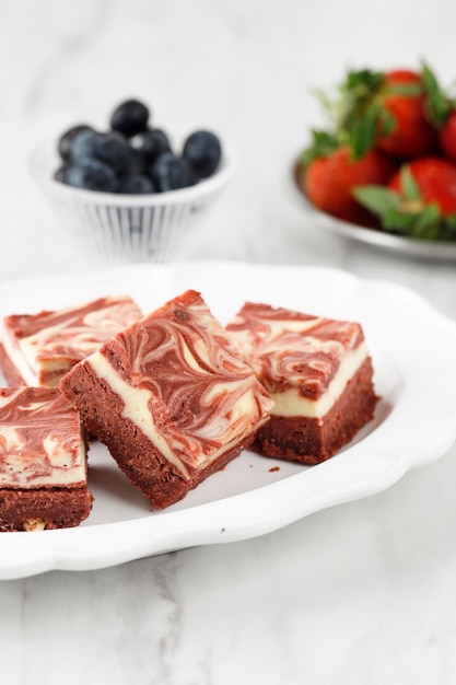 Brownies de queijo creme de veludo vermelho na placa de cerâmica branca