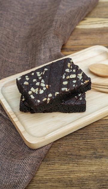 Brownies-Kuchenlöffel und -gabel auf einem Holztisch