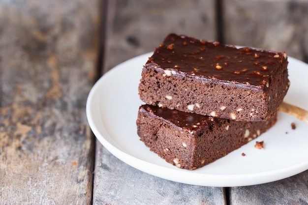 Foto brownies na placa branca com mesa de madeira.