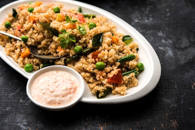 Foto bruchweizen oder daliya upma, serviert in einer schüssel. selektiver fokus