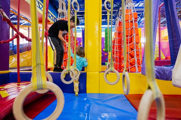 Bruder mit Schwester spielt auf dem Spielplatz im Indoor-Spielzentrum