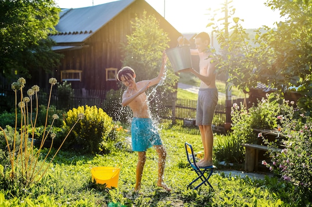 Foto bruder spielt mit wasser im hinterhof