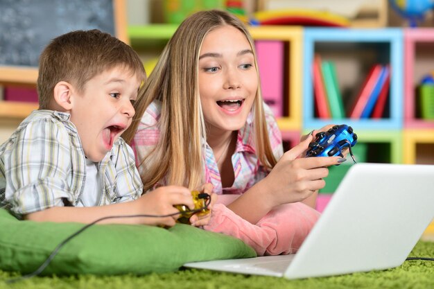 Bruder und Schwester spielen Computerspiel auf dem Laptop