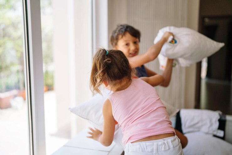 Foto bruder und schwester spielen zu hause kissenkampf