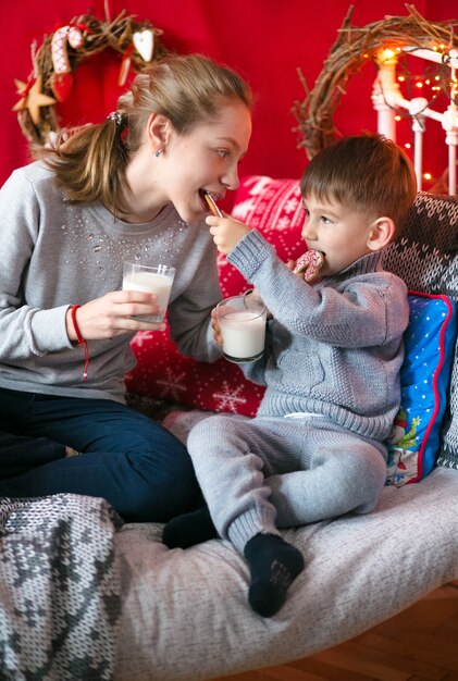 Bruder und Schwester umarmen sich, haben Spaß, in dem Haus, das für das neue Jahr eingerichtet wurde