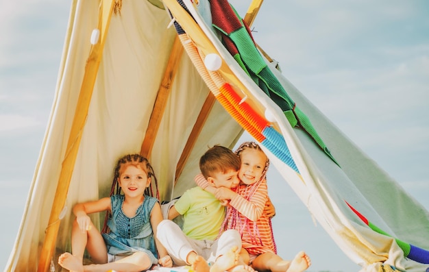 Bruder und Schwestern spielen zusammen Glückliche Kinder, die im Zelt spielen Nette Kinder beim Camping Spaß haben