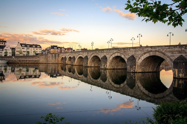 Brücke über den Fluss gegen den Himmel beim Sonnenuntergang