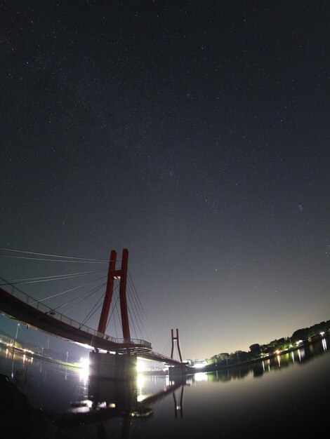 Brücke über den Fluss gegen den Himmel in der Nacht