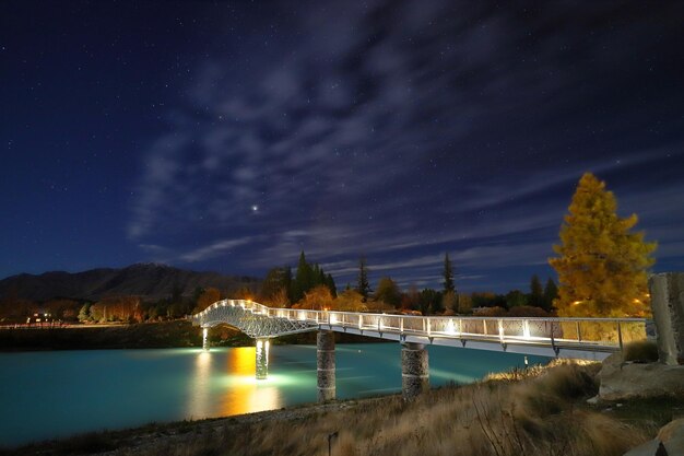 Foto brücke über den fluss gegen den nachthimmel