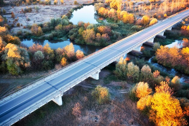 Brücke über den Fluss und Herbstgelbwald im Berggebiet