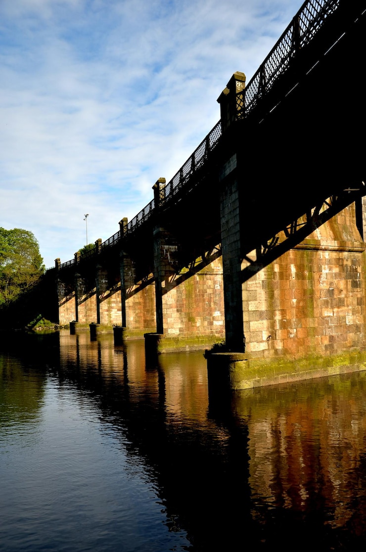 Foto brücke über einen fluss mit gebäuden im hintergrund