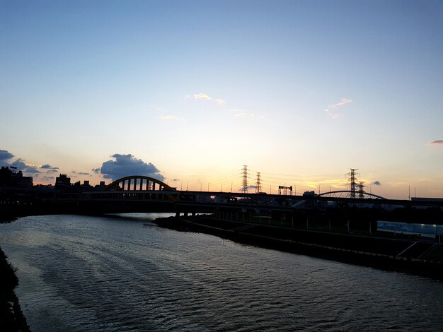 Foto brücke vor dem fluss gegen den himmel bei sonnenuntergang